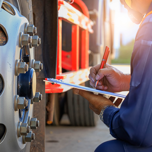 Maintenance technician performing preventative maintenance checks on vehicle